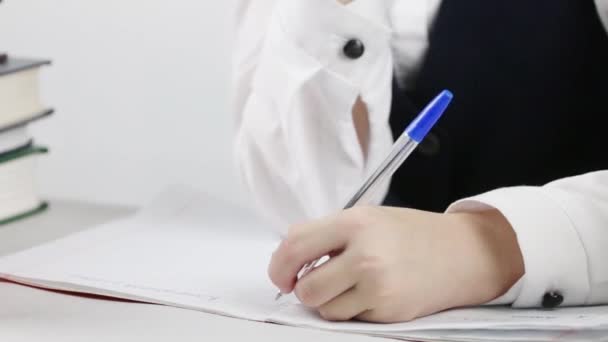 Schulmädchen schreibt in Schulheft am Tisch, Nahaufnahme, Neigung — Stockvideo