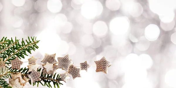 Tannenzweig und verschwommene Weihnachtsbeleuchtung im Hintergrund — Stockfoto