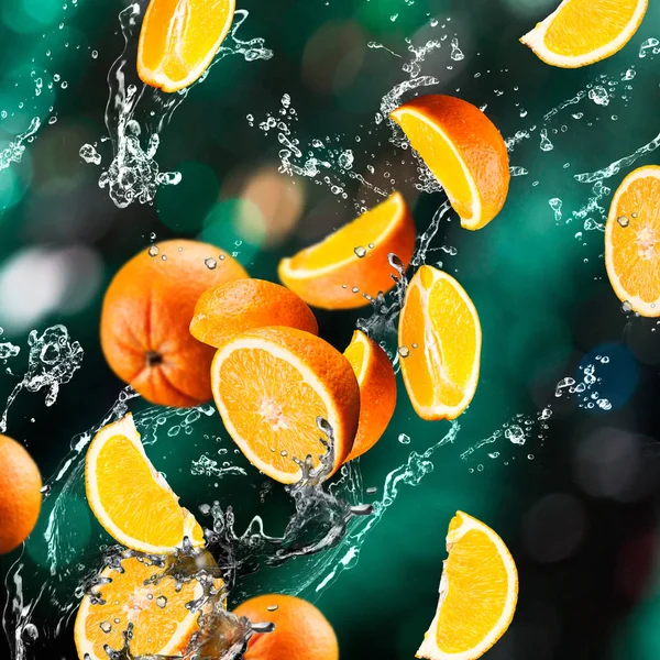 Oranje vruchten en spatten water — Stockfoto