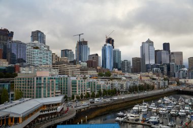 Bulutlu bir sabahta Seattle silueti. Tekneler limana yanaştı..