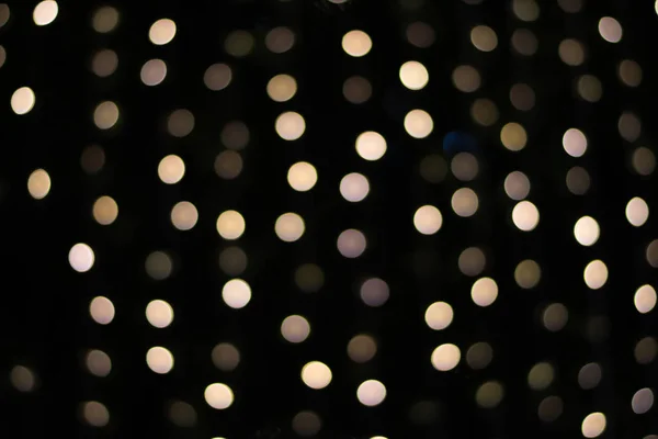 Bokeh dourado em um fundo preto, luzes embaçadas — Fotografia de Stock