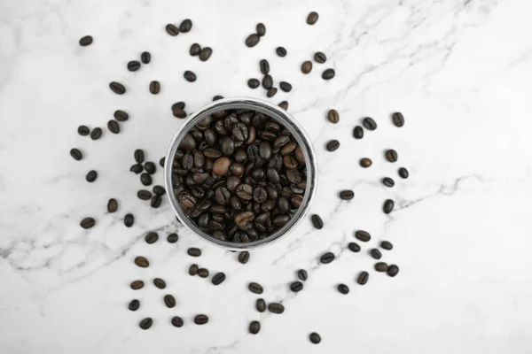 Кофейные зерна в стакане на мраморном полу в верхнем виде, Кло — стоковое фото