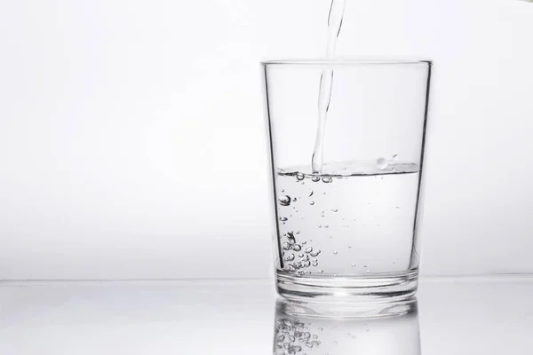 Häll rent vatten i ett glas och drick klart. — Stockfoto