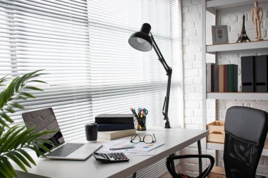 Ofisteki pencerenin yanında fotokopi alanı olan modern beyaz masa.