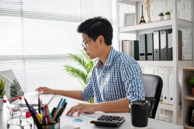 İş adamları ofisin penceresinde ciddi şekilde çalışırlar.