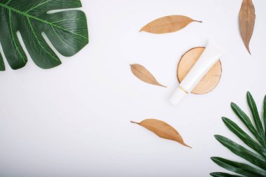 Beyaz arka planda yaprakları olan doğal kozmetikler.