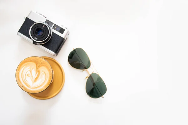 Horká káva s filmovou kamerou a slunečními brýlemi na bílém pozadí — Stock fotografie