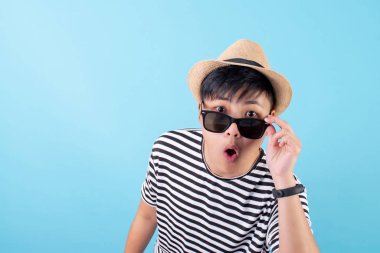 A young Asian traveler wearing a shocked and excited T-shirt wit