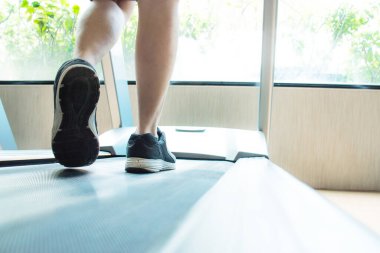 Koşu bandında koşan ve spor salonunda egzersiz yapan koşucunun ayakkabılarının yakın plan çekimlerinde kaslar var. Sağlık hizmeti kavramı