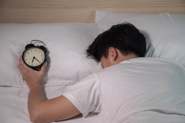 Asyalılar beyaz bir yatakta çalar saatle uyurlar..