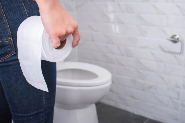 Ręce Trzymające Rolkę Papieru Toaletowego Idące Łazienki Toaleta Tle Koncepcja — Zdjęcie stockowe