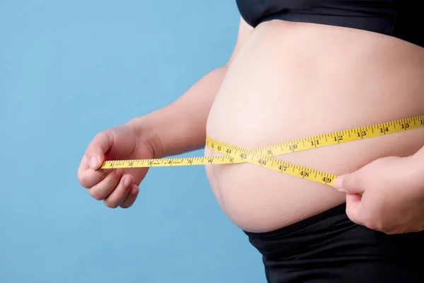 太りすぎの女性の肖像彼女の腹の脂肪を測定 — ストック写真