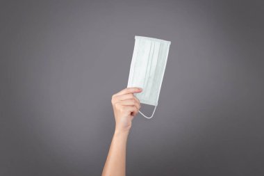 Arka planda izole edilmiş bir maske tutuyor..