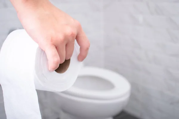Zamknij Dłoń Trzymając Papier Toaletowy Toalecie — Zdjęcie stockowe