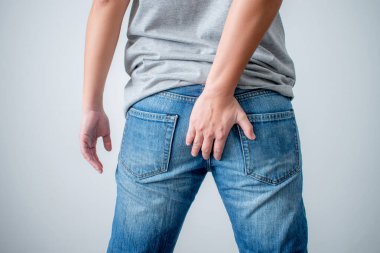 The young man touched his butt because of stomachache and hemorrhoids. Concepts of health care and bowel problems.