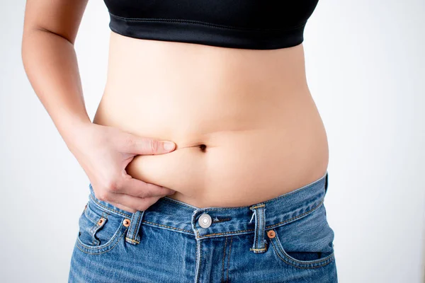 A close up of a woman\'s hand that grabs belly fat. With isolated background.