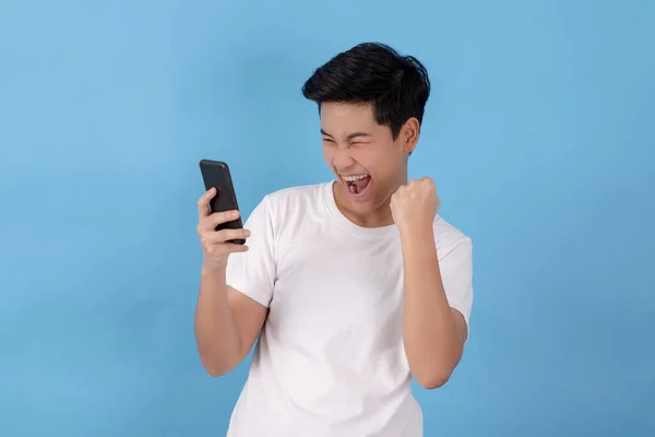 Ázsiaiak Izgatottak Boldogok Amikor Mobiltelefonokat Néznek Világoskék Háttérrel Elszigetelve Stúdióban — Stock Fotó