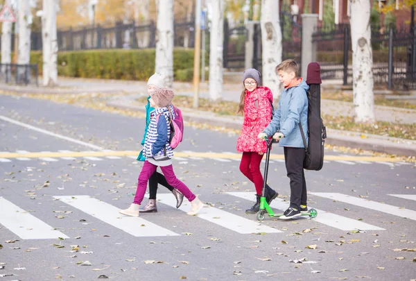 children go to school on the sidewalk with a fun company.