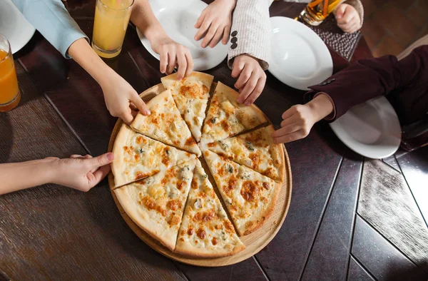 children eat pizza in a restaurant.