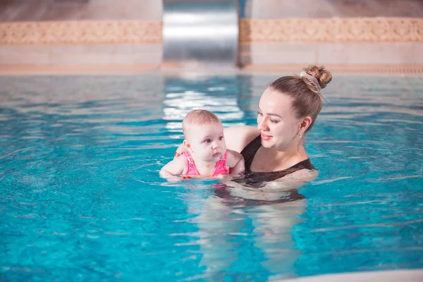 young mother teaches her child to swim