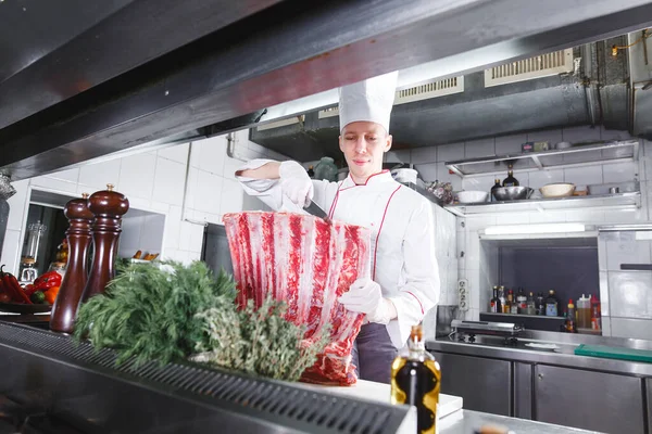 cook cooks beef steak in the restaurant kitchen