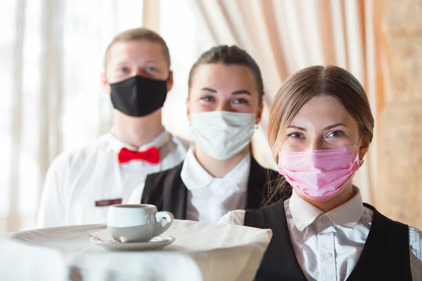 work of a waiter in a restaurant in a medical mask