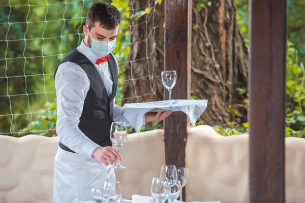 the waiter works in a restaurant on the summer terrace