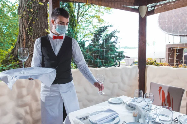 the waiter works in a restaurant on the summer terrace