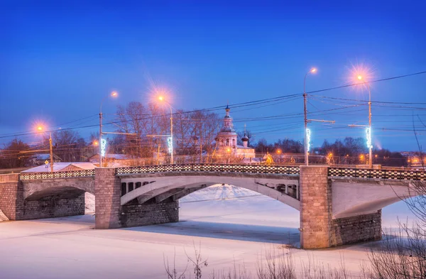 ヴォロダ市のヴォロダ川に架かるオクタイブラスキー自動車橋と冬の夜に反対側のドミトリー プリルツキー教会 — ストック写真