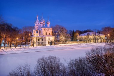 Vologda Kremlin 'in karşısındaki John Chrysostom Kilisesi. Bir kış gecesinde Vologda Nehri 'nin setinden manzara.