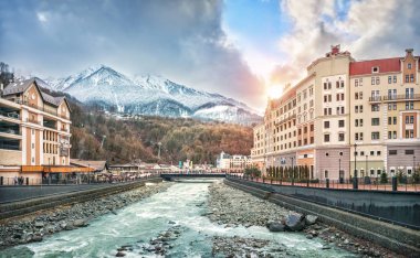 Evleri, otelleri, dükkanları, Mzymta Nehri 'ni ve güneşli bir günde Soçi' deki Rosa Khutor 'daki dağların karlı tepelerini görmek..