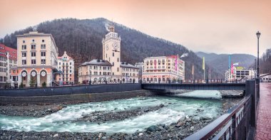 Belediye kulesi, oteller, Romanov köprüsü, Mzymtu nehri ve Soçi 'deki Rosa Khutor dağlarının karlı tepeleri..