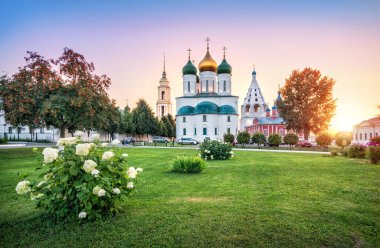 Kolomna Kremlin 'in Varsayım Katedrali, Tikhvin Kilisesi ve güneşli bir yaz akşamında çiçek çayırı manzarası