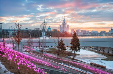 Moskova 'daki Kotelnicheskaya Embankment' ta Zaryadye Park 'tan yükseltilmiş bir bina ve güneşli bir kış sabahı renkli toplar.
