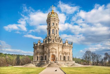 Dubrovitsy 'deki Znamenskaya Kilisesi Mavi bir gökyüzü ve beyaz bulutlar altında Ve güneşli bir bahar gününde bir köpek