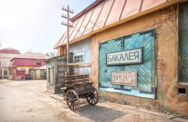 Güneşli bir bahar gününde, Leninsky Gorky 'de Kinogorvodka' da eski bir şehir caddesinde bir bakkal binasının yapay manzarası. Market işaretleri. Stok.