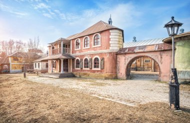 Leninsky Gorky 'deki Kinogorodok' un eski caddesinde güneşli bir bahar gününde iki katlı bir evin yapay manzarası ve bir fener..