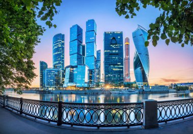 Moskova City gökdelenleri bir yaz akşamı yeşil ağaçlar ve açık çitlerle çevrili.