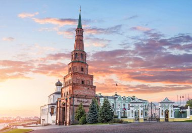 Kazan Kremlin 'deki Suyumbike Eğik Kulesi ve pembe günbatımı gökyüzünün altında bayrağı olan hükümet binası