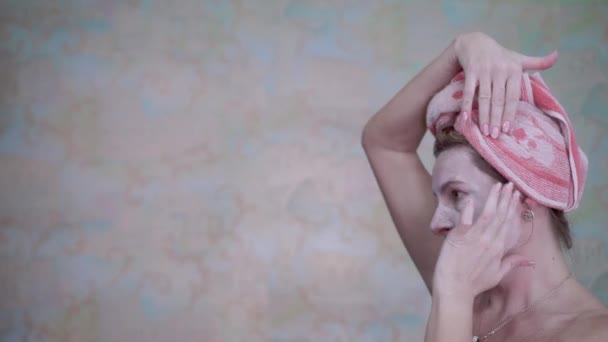 一位头戴毛巾的妇女戴上化妆品面罩 使皱纹年轻化 并使皱纹平缓 温泉治疗 防止皱纹和皮肤老化 — 图库视频影像