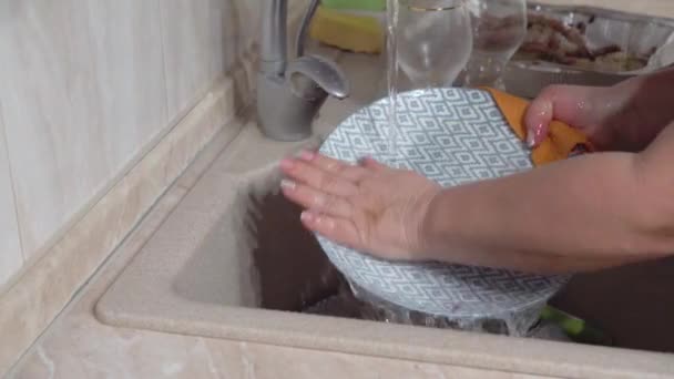 女人在厨房的洗碗池里用手洗盘子 做家里的家务活 洗碗常规 静态相机 — 图库视频影像