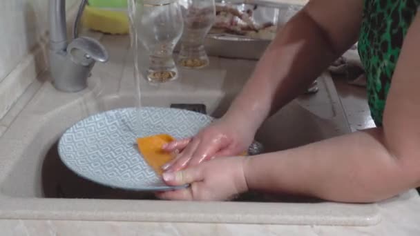 여자들은 싱크대에서 접시를 씻는데 집에서 집안일을 정적인 카메라 — 비디오
