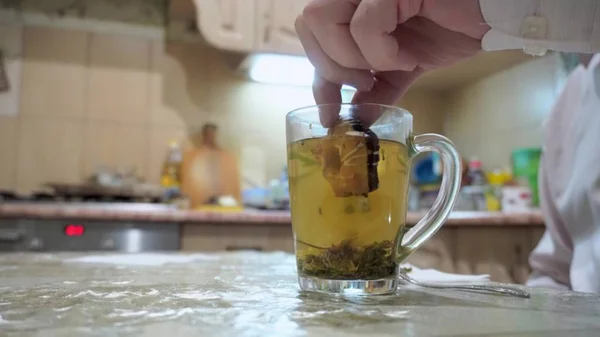 Мужчина пьет ароматический зеленый чай. Опускает печенье в чашку . — стоковое фото
