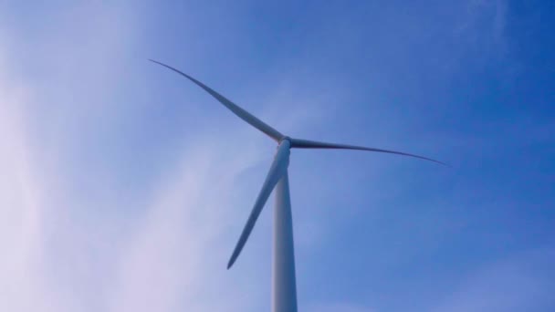 青い空の背景にある風力タービンの回転翼 緑のエネルギーの発生 — ストック動画