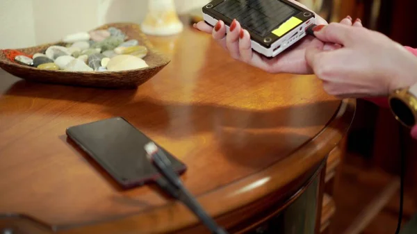 Kız cep telefonunu dış bataryaya bağlıyor. Sığ alan derinliği.