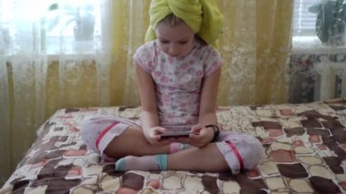 Çocuk elinde akıllı bir telefonla hevesle bir oyun oynuyor..