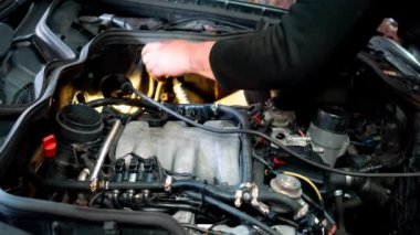 Araba motorunu tamir ediyorum. Bir benzin istasyonu. Tamirci motoru kontrol eder ve arızayı düzeltir..