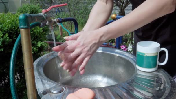 一个女人在她家院子里用肥皂彻底洗手 — 图库视频影像