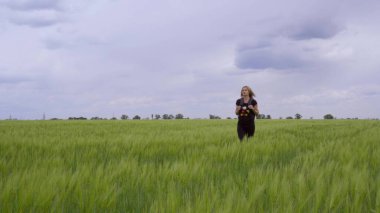 Sırt çantasıyla gezen genç bir kaşif ya da gezgin buğday tarlasında yürüyor..