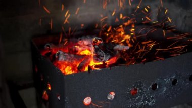 Sönen ateşin kömürlerini ateşle. Rüzgarın esintisi, kıvılcımlar.